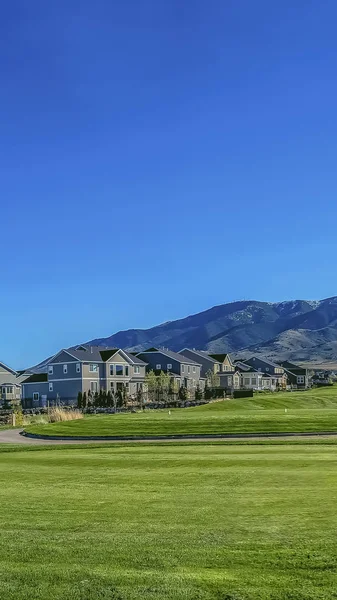Área residencial vertical em um vale com vista para a montanha sob o céu azul e sol brilhante — Fotografia de Stock