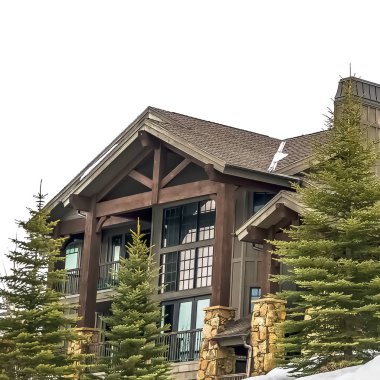 Kare çerçeve Bulutlu bir kış gününde taze kar ortasında güzel bir ahşap evin dış