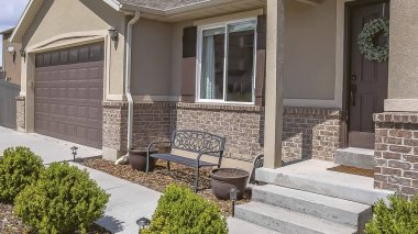 Garaj kapısı ve ön kapıya giden garaj yolu ve merdivenlerile Panorama çerçeve Ev cephesi