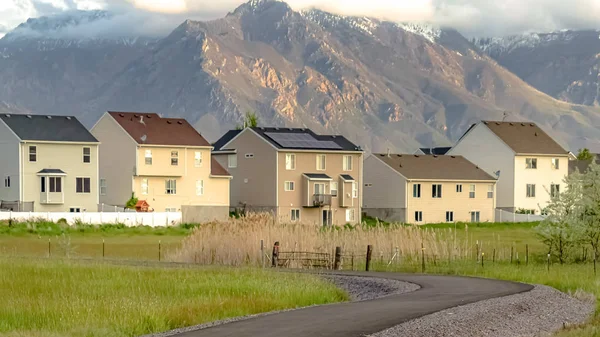 Πανόραμα δρόμος που οδηγεί σε υπέροχες κατοικίες ορόφων με το βουνό στο παρασκήνιο — Φωτογραφία Αρχείου