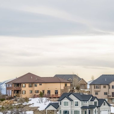 Kare çerçeve Kışın bulutlu gökyüzüne karşı karla kaplı bir yamaç üzerine inşa edilmiş çok katlı evler