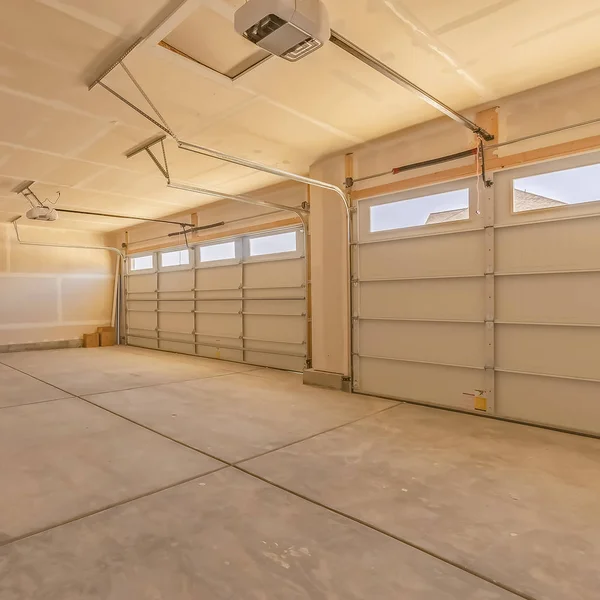 Інтер'єр порожнього гаража з двома великими дверима і маленькими прямокутними вікнами — стокове фото