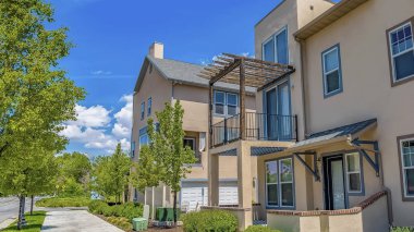 Mavi gökyüzünün altında balkonlu ve verandalı evlerin önündeki panorama çerçeve Beton yol