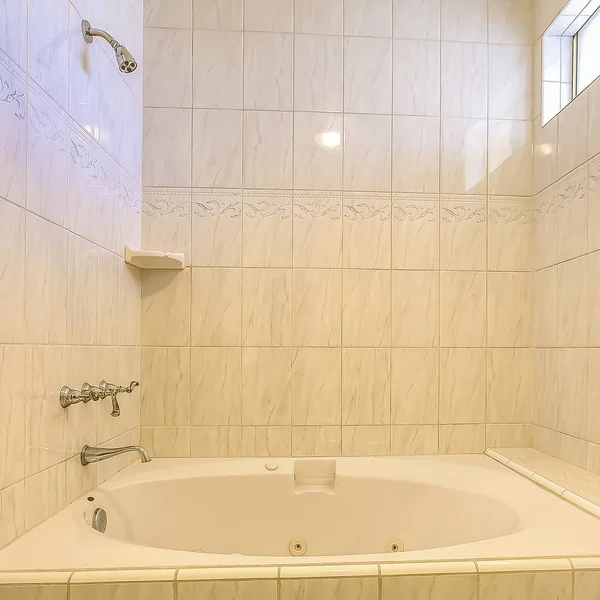 Built in bathtub and shower inside a bathroom with shiny wall and small window — Stock Photo, Image