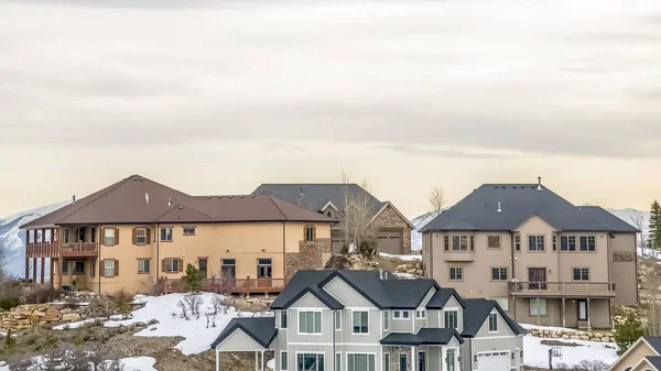 Panorama Çok katlı evler kışın bulutlu gökyüzüne karşı karla kaplı bir yamaç üzerine inşa