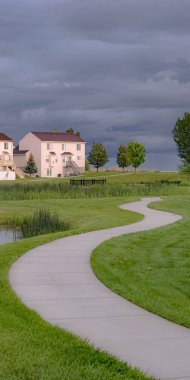 Kalın gri bulutlar ile gökyüzü altında gölet köprü ve yol ile Dikey Mahalle parkı