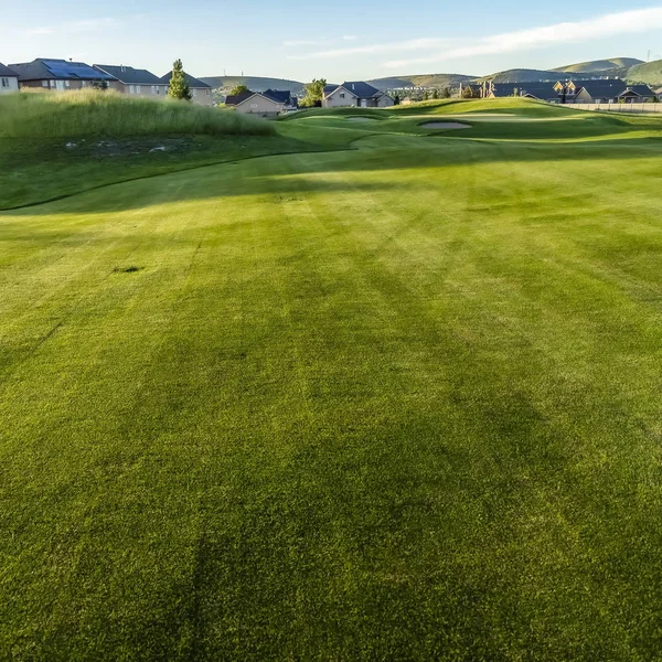 Szögletes keret Fairway és bunkerek egy golfpálya otthonokkal és hegyi a távolban — Stock Fotó