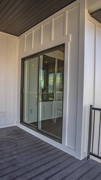 Vertical Home balcony with wooden floor metal railing and sliding glass access door