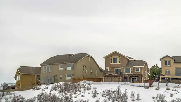Panorama-Rahmen mehrstöckige Häuser auf einem Hügel unter einem riesigen bewölkten Himmel an einem kalten Wintertag — Stockfoto