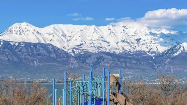Güneşli bir günde göl ve karla kaplı dağ manzaralı Panorama Oyun Alanı