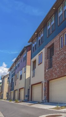 Güneşli bir günde mavi gökyüzü altında çok katlı evlerin ortasında Dikey çerçeve Yol