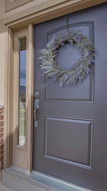 Dikey Veranda ve çelenk ve yan ışıklar ile ön kapı güneşli bir günde görüntülenen