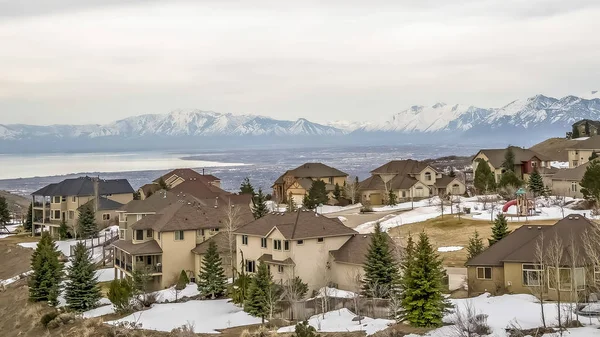 Cadre panoramique Quartier résidentiel sur une colline avec vue sur la vallée du lac et la montagne en hiver — Photo