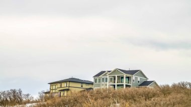 Panorama çerçeve Kışın karla kaplı dağda çok katlı ev üzerinde Parlak bulutlu gökyüzü