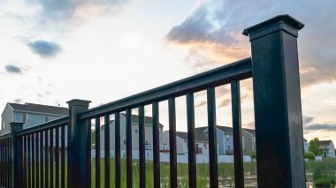 Arka planda çok katlı evler ve bulutlu gökyüzü ile bir gölet üzerinde Panorama Köprüsü