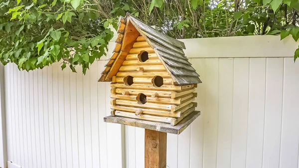 Panorama Gros plan de nichoir en bois avec plusieurs trous d'entrée dans la cour d'une maison — Photo