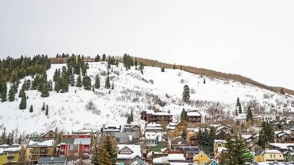 Panorama Vaste ciel nuageux sur des maisons construites sur une colline recouverte de neige fraîche en hiver — Photo