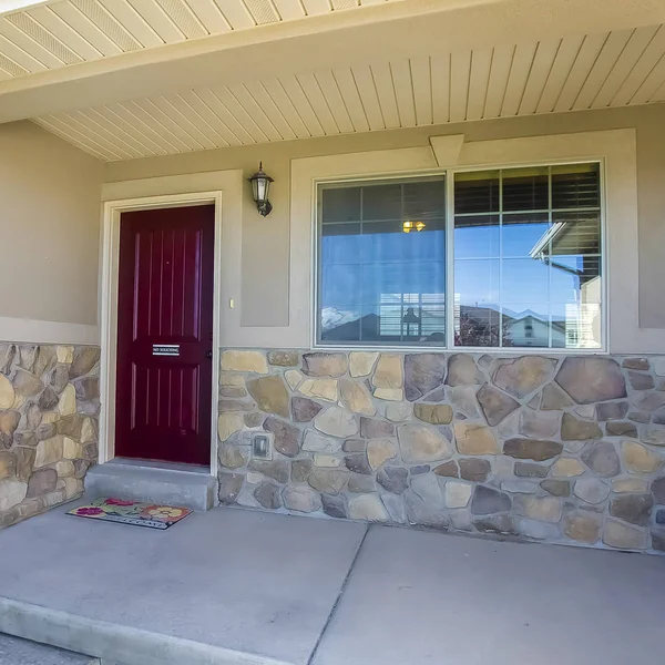 Фасад дома с коричневой входной дверью и сочетанием бетона и каменной стены — стоковое фото