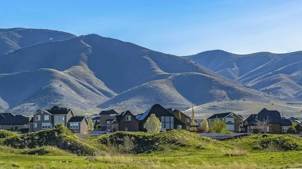 Ramka Panorama domy na terenie pokryte traw pod błękitne niebo w słoneczny dzień — Zdjęcie stockowe