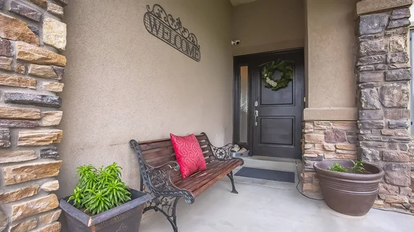 Panorama Fachada de casa con cartel de bienvenida al banco y plantas en maceta en el porche — Foto de Stock