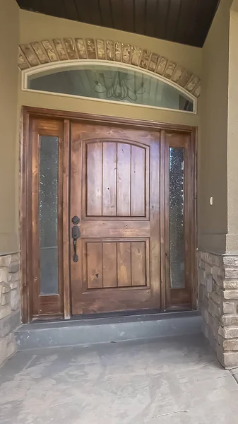 Marco vertical Fachada de casa con puerta de madera marrón esmerilados laterales y ventana abovedada — Foto de Stock