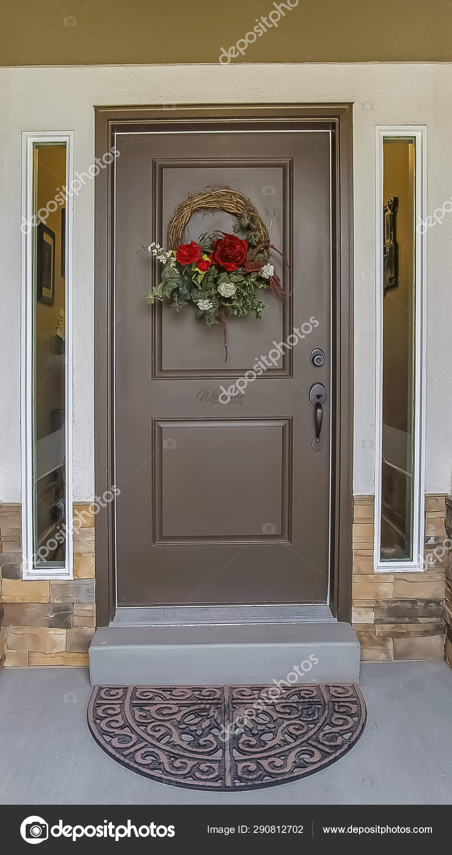 Vertical Frame Floral Wreath Hanging On The Gray Front Door Of A