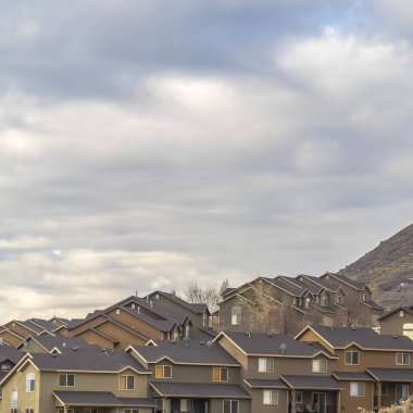 Bulutlu gökyüzü havai manzaralı bir dağ yamaç üzerine inşa edilmiş evlerin Kare çerçeve Satırlar