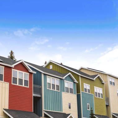 Güneşli bir günde mavi gökyüzü ve bulutlara karşı balkon ve verandalı Kare Evler