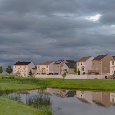 Parlak bir gölet ve geniş çimenli alan manzaralı Square Beautiful evleri