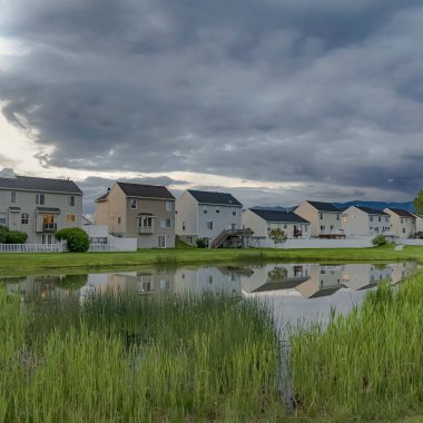 Güzel aile evleri ve parlak gölet ile doğal bir mahalle üzerinde Kare Overcast gökyüzü
