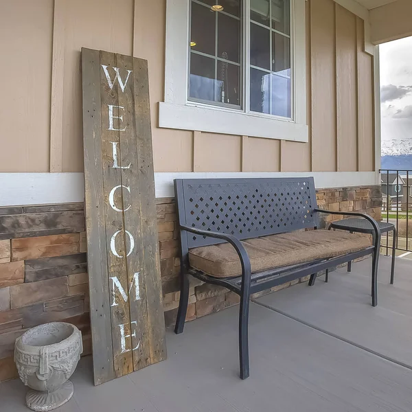 Bir rezidans ön verandada Kare Ahşap Hoş geldiniz işareti ve mobilya
