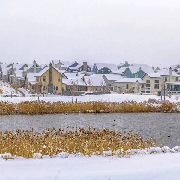 Fyrkantig sjö med Grädda och snötäckta strand på en molnig vinterdag — Stockfoto