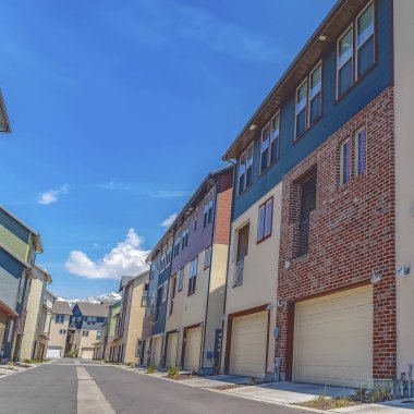 güneşli bir günde mavi gökyüzü altında çok katlı evlerin ortasında çerçeve Yol