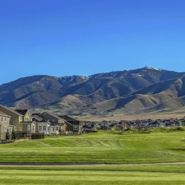 Vadideki evlere giden geniş bir çimenli arazi üzerinde Kare çerçeve Asfalt yol