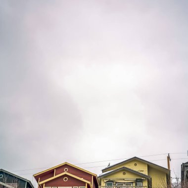 Kare çerçeve Kışın renkli evler ve karla kaplı zemin üzerinde geniş bulutlu gökyüzü