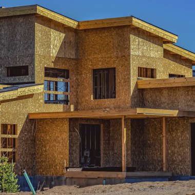 Güneşli bir günde mavi gökyüzü altında yapım aşamasında bir evin Kare Dış görünümü