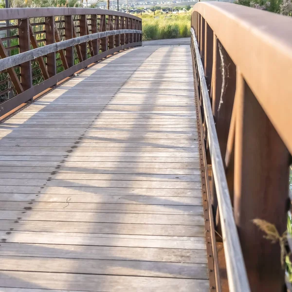 Plaza Primer plano de un puente con cubierta de madera y barandilla de celosía marrón en un día soleado —  Fotos de Stock