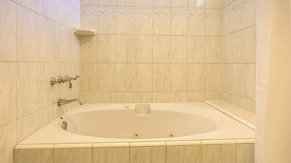 Panorama frame Built in bathtub and shower inside a bathroom with shiny wall and small window