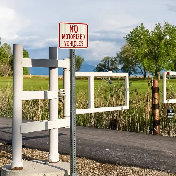 Square Road con puerta blanca y cartel contra los árboles y el campo de hierba en un día soleado — Foto de Stock