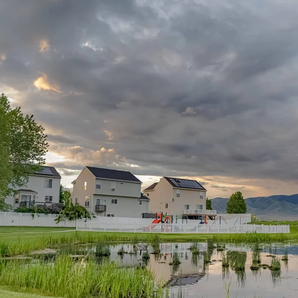 Kare Parlak gölet oyun alanı ve çok katlı evler geniş çimenli arazi ile çevrili