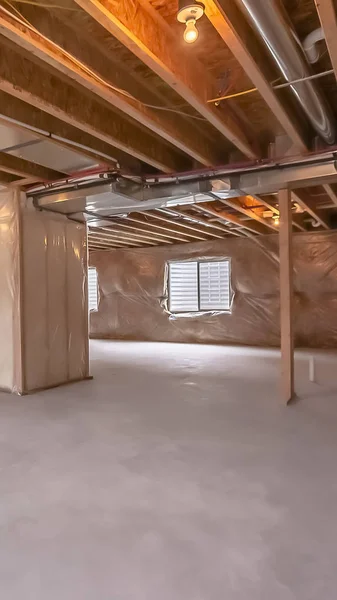 Vertical frame Home under construction with interior framing beams and plastic covered wall — Stock Photo, Image