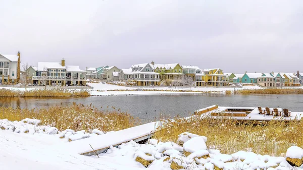 Panorama Lago rodeado de nieve cubierta de tierra y bajo cielo nublado en invierno — Foto de Stock