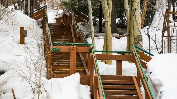 Panorama Escaleras exteriores en una ladera montañosa cubierta de nieve durante el invierno — Foto de Stock