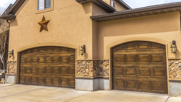 Panorama Fachada de hermosa casa con dos puertas de garaje de madera marrón contra el cielo nublado — Foto de Stock