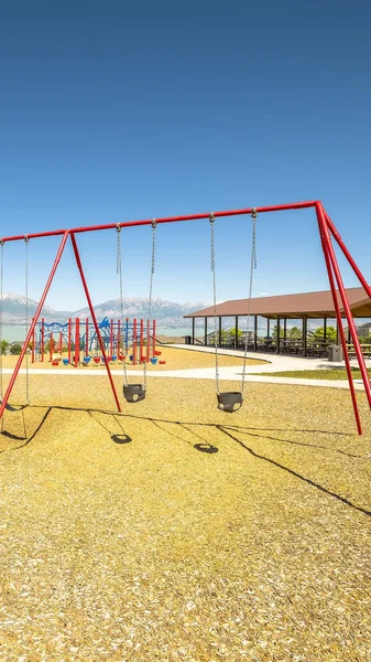 Vertical Park with swings and pavilions and scenic view of lake and snow capped mountain — Stock Photo, Image
