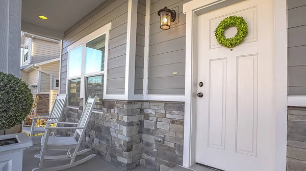 Panorama frame Facade of a home with a simple wreath hanging on the white wooden door — Stock Photo, Image