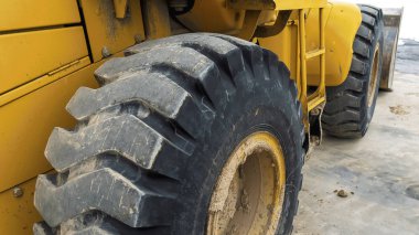 Panorama Sarı bir inşaat makinesinin siyah kauçuk tekerleğinin yakın görünümü