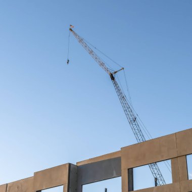 Kare Bitmemiş bina dış ve mavi gökyüzü arka plan ile inşaat vinç