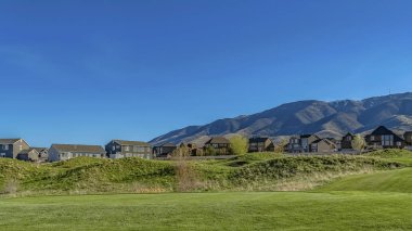 Panorama Yemyeşil otlarla kaplı geniş bir çimenli arazi üzerinde dar asfalt yol