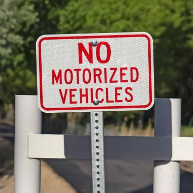 Kare No Motorlu Araç işareti güneşli bir günde beyaz bir kapı ve dar bir yol karşı